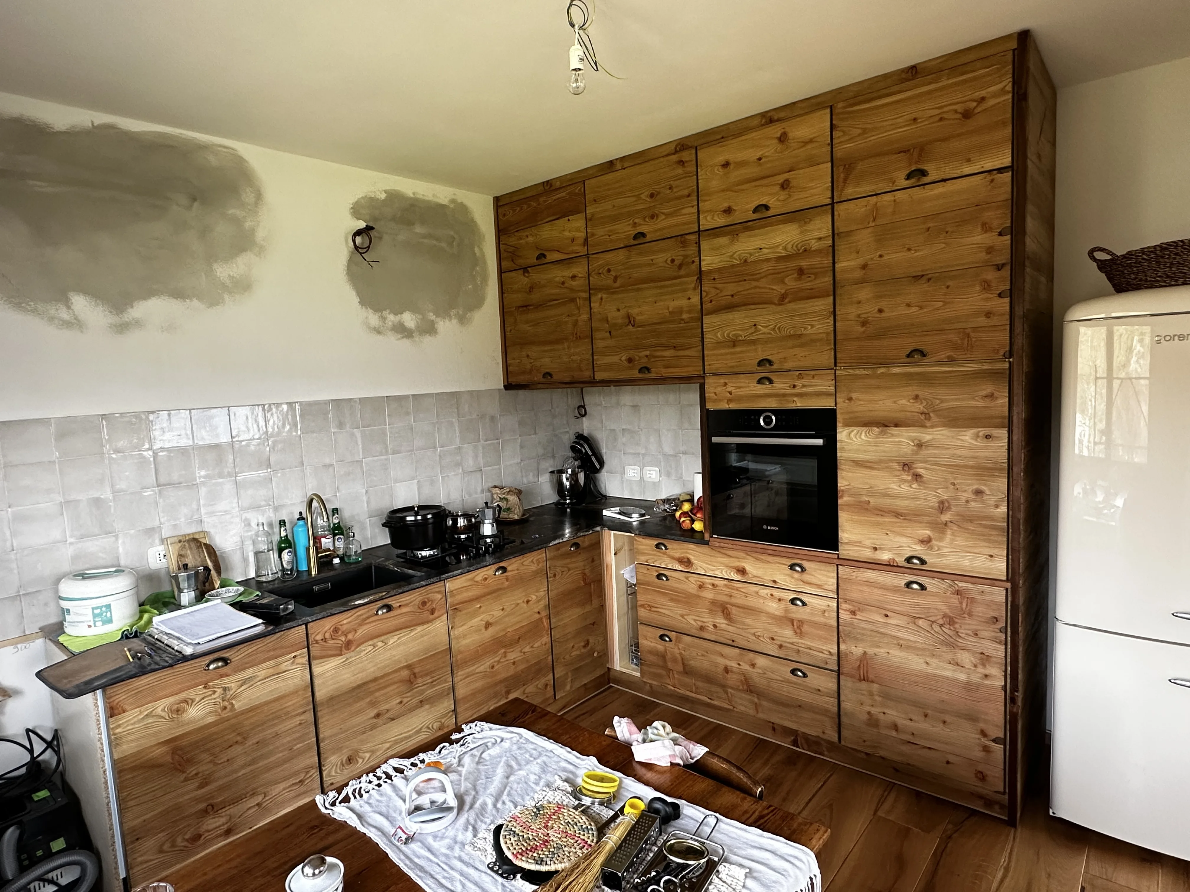 Cucina artigianale in legno con ante a doghe e forno da incasso